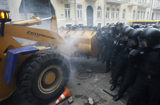 Protesters use a tractor to break through police lines near the president's office on Dec. 1, 2013. [Reuters]